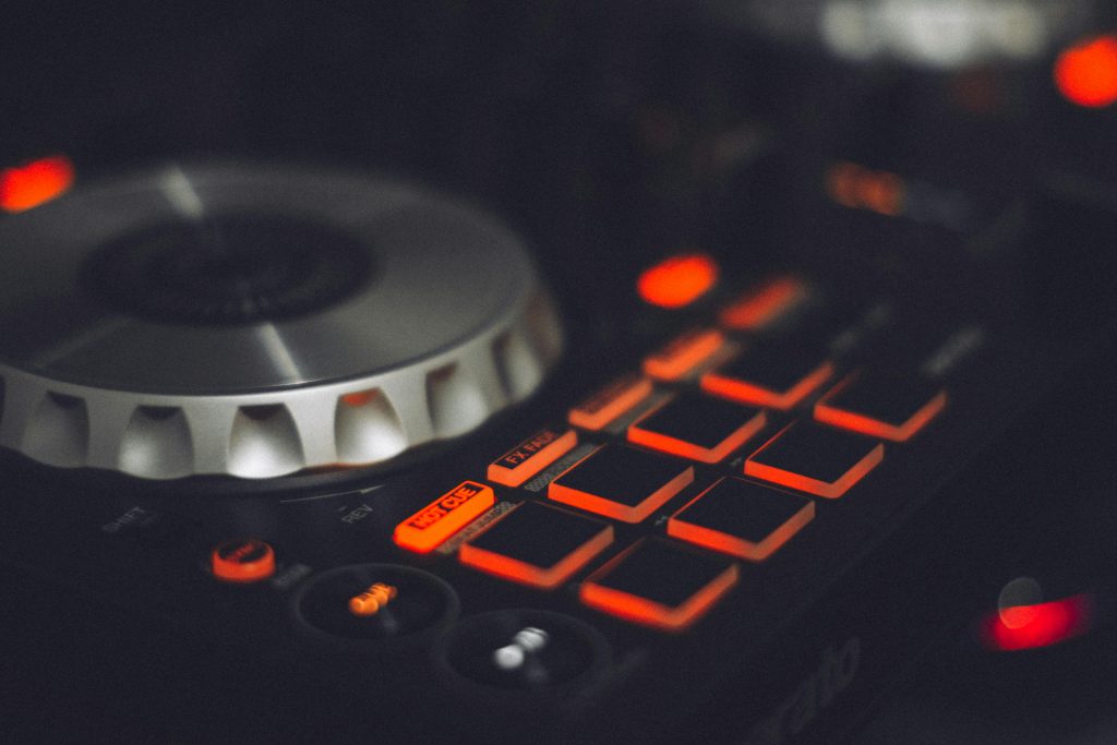 Close-up of a DJ controller with illuminated buttons and control knobs, ideal for music technology themes.